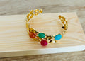 Pulsera rígida dorada con piedras de colores