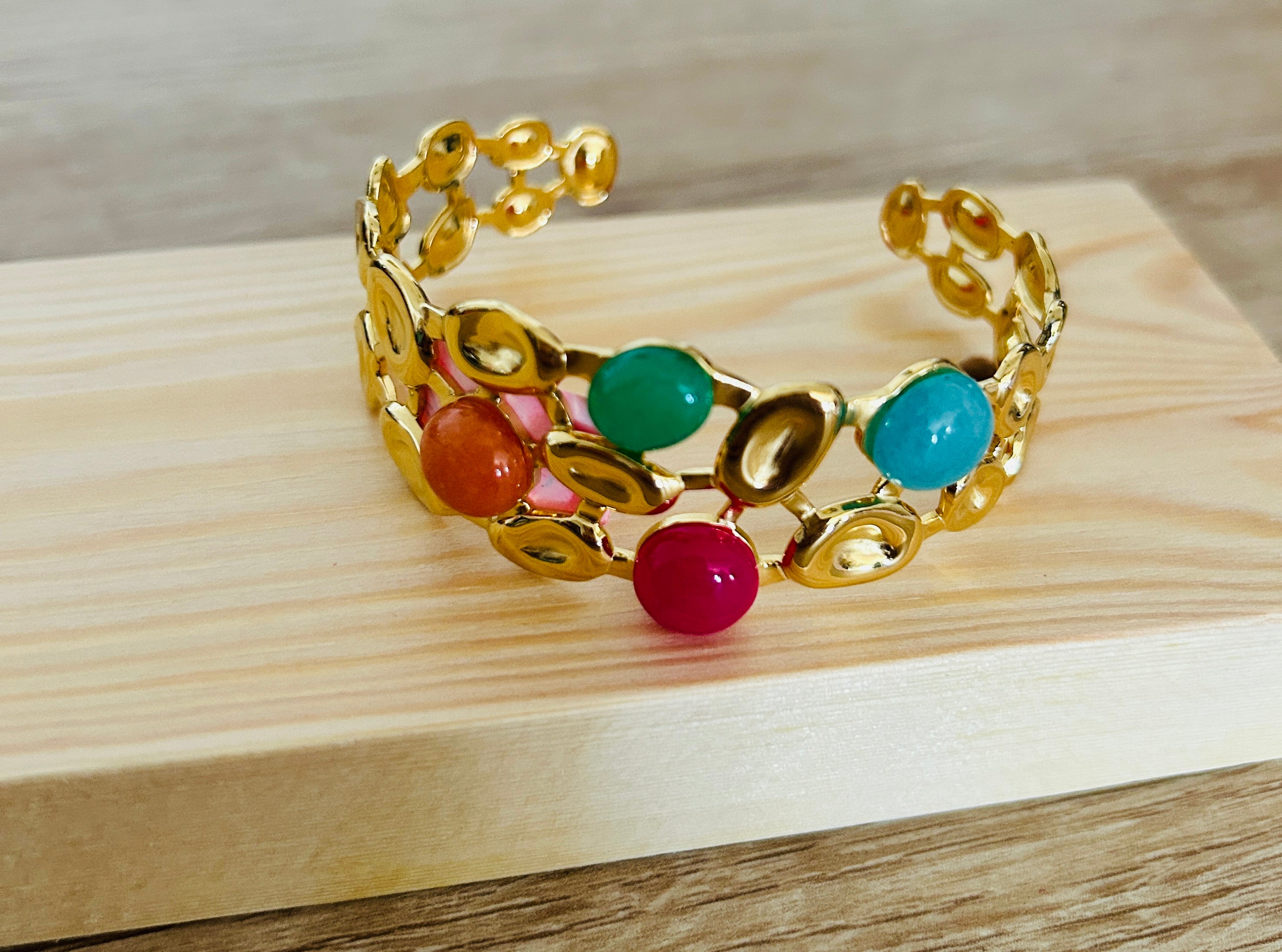Pulsera rígida dorada con piedras de colores