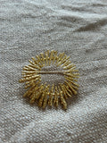 Broche Dorado con Diseño Circular Rayo de Sol